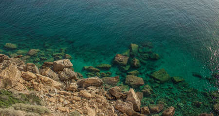 tropic vivid colorful mountain rocks and blue green water surface with waves from above in warm...