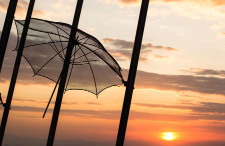 sunset orange sky romantic evening landscape with street outdoor exterior object hanging umbrella on high pillar black silhouette shape, copy space for your text hereの写真素材