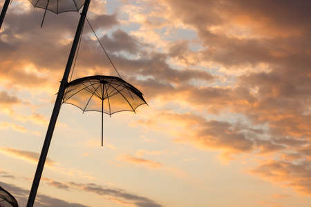 hanging umbrella silhouette city street outdoor exterior object on evening sunset sky background landscape copy space for textの写真素材