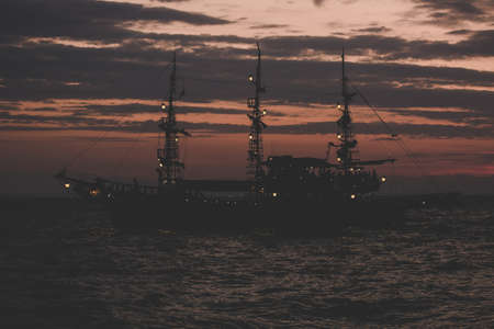 pirates concept of soft focus old vintage ship silhouette on sea water surface in romantic lighting twilight evening time after sunset copy spaceの写真素材