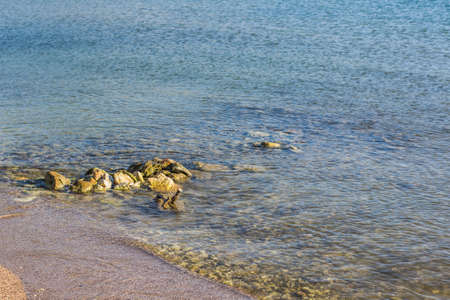 sea sand tropic beach shoreline with stone on waterfront district in water, wallpaper background...