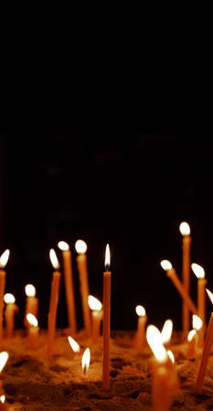 candle yellow illumination religion spiritual atmospheric praying concept in vertical picture black background empty copy space for your textの写真素材