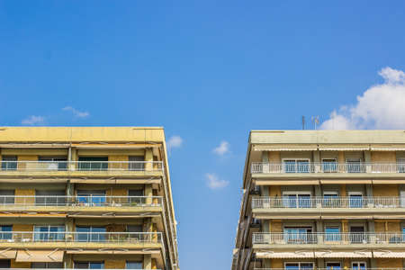 common apartment building symmetry facade of front side with balcony and windows on clear blue sky background copy space for your text hereの写真素材