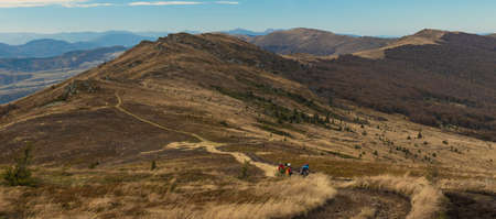 moody mountain landscape top scenic view hiking group of people back to camera panoramic nature spaceの写真素材