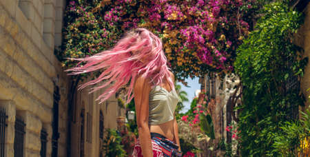 fluttering hair motion woman turn around in outdoor spring time sunny weather garden city street space unfocused background environmentの写真素材