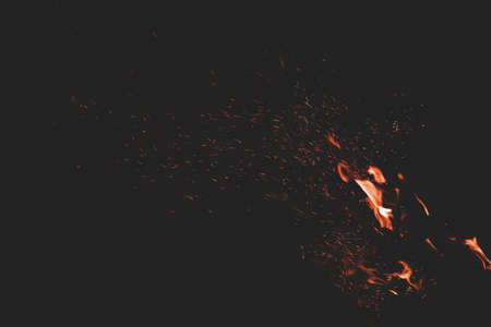 fire flame orange sparkles motion in dark wallpaper pattern background space for copy or your text hereの写真素材