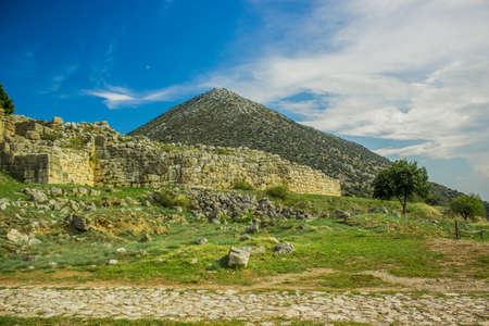 ancient city stone wall ruins in spring bright colorful valley landscape with lonely mountain and...