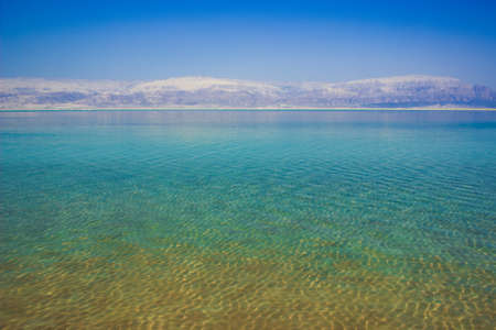 unfocused Dead sea peaceful water surface and background mountains ridge in morning fog Middle East...