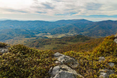 moody foggy mountain top view highland rocky landscape in autumn season cloudy day time stones ground foreground and plateau background spaceの写真素材