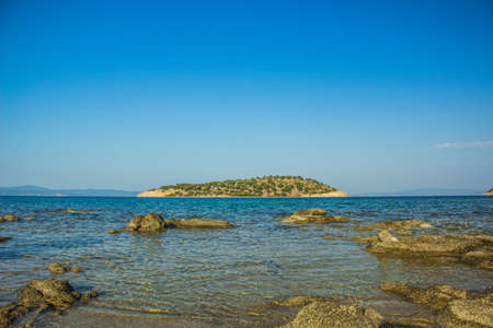 Mediterranean sea island landscape rocky shore line foreground and horizon board with blue sky background empty copy space for your text, beautiful destination for relaxation in summer vacation timeの写真素材