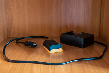 photo camera battery and charger equipment objects om wooden wardrobe shelf wooden furniture cell...
