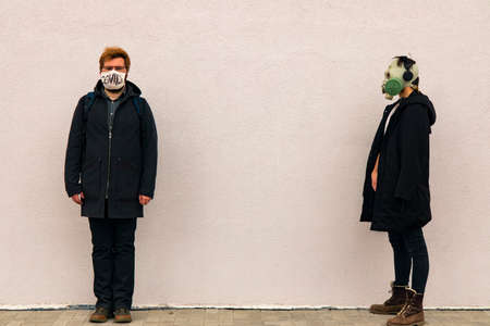 banter concept picture of two man portraits in medicine mask and gas mask hipster style cloth in...