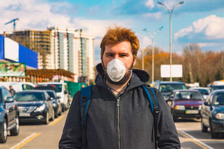 man medicine mask in overcrowded city district shopping center parking place outdoor pollution environment conditionsの写真素材