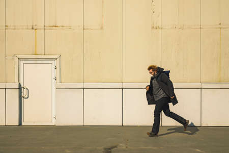 man in mask run alone on street factory white wall and door simple background industry spaceの写真素材