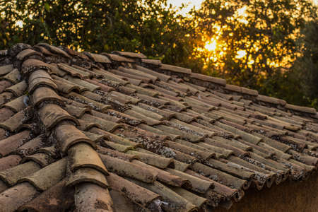 old dirty brown shingle house soft focus roof outdoor in evening sunset time with sun rays background, rural environment placeの写真素材