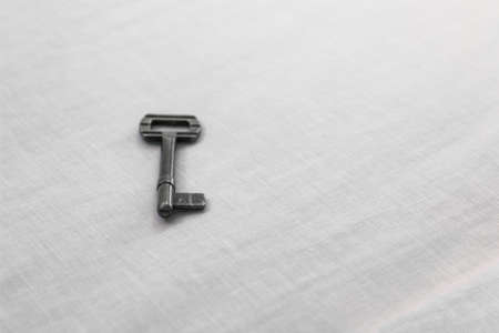 soft focus old rustic key iron material on white sheet surface simple background space for copy or your text hereの写真素材
