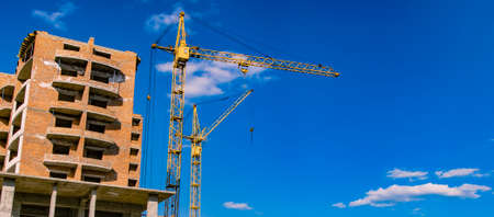 construction building process crane object brick house shape urban landmark photography foreshortening from below on vivid blue sky empty copy space for your text hereの写真素材
