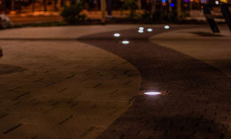 night street square walking paved road tile floor soft focus surface with lantern lighting from groundの写真素材