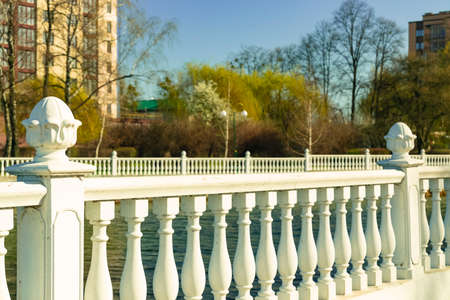 city walk site waterfront in park outdoor district spring time season with marble fence foreground and apartment buildings unfocused silhouette background spaceの写真素材