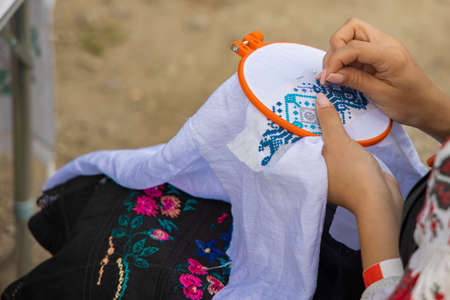 crafting embroidery creative hand made process by tender female hands making beautiful Ukrainian traditional symbols and colorsの写真素材