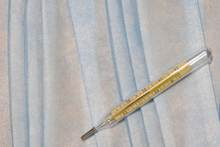 medical thermometer simple concept picture with soft blue textile cloth background texture surface...