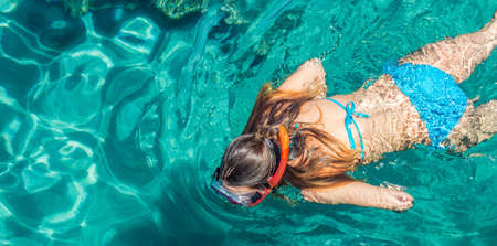 swimming girl in the sea water tropic summer vacation activity time wallpaper poster pictureの写真素材