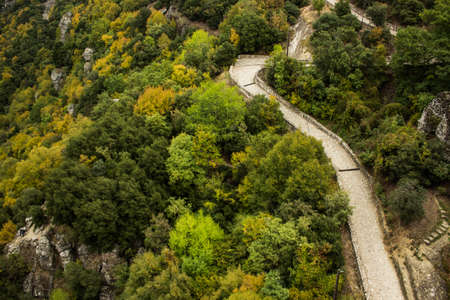 aerial nature landscape photography of paved curved narrow pilgrim road path way in highland...