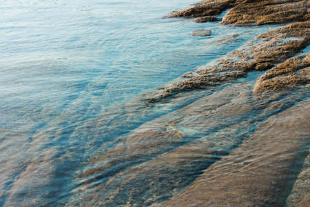 stone bottom shallow water shore line simple background of nature scenic viewの写真素材