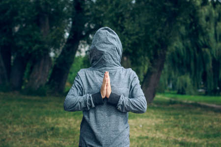 upside down clothes hood with hidden person in pray pose concept pictureの写真素材