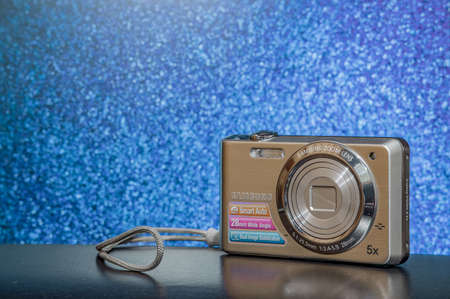 Lviv / Ukraine - 05.15.2020 : old digital camera from 2000 year advertising poster studio lighting on festive blue bokeh background view and empty copy space for your text hereのeditorial素材