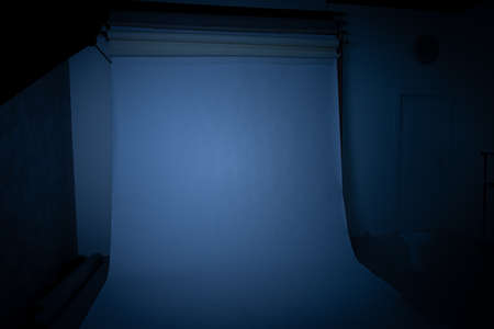 soft focus rustic dark studio environment with poor white paper background object and light turn off blue color toning horror style indoor spaceの写真素材