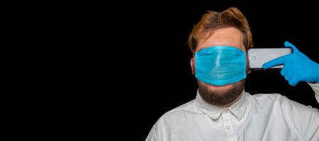 global pandemic health care crisis concept male person portrait with blindness by face mask respiration tool and phone near head, depressive mood theme studio photography poster copy space for textの写真素材