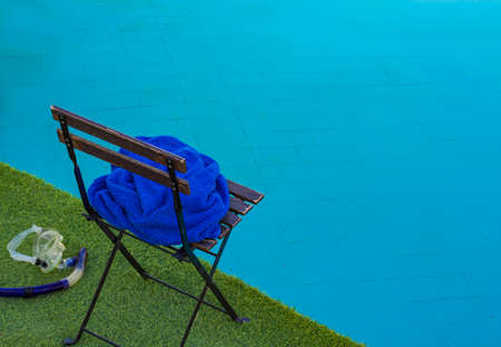 rustic swimming pool back yard space with chair and snorkeling mask near blue water space simple background pattern copy spaceの写真素材