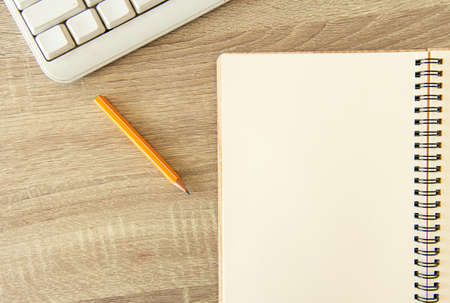 office simple background pattern with white paper notebook pencil and keyboard on table top view...