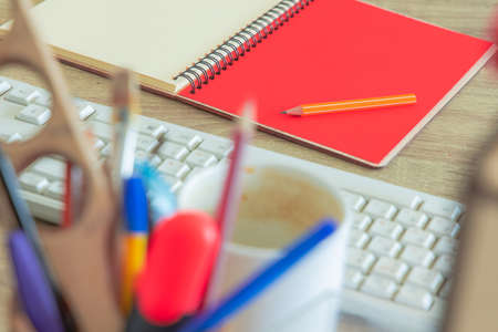 office table tools notebook paper pencil and keyboard indoor view working space