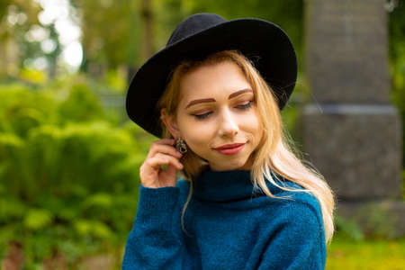 tender nice and cute blonde girl face portrait photography with blurred outdoor background scenic
