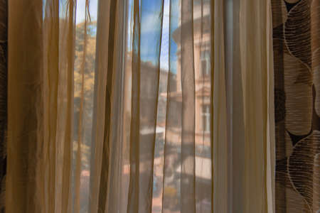 morning view from inside curtains in room interior object and opposite building outside spaceの写真素材