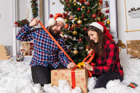 Christmas holidays couple have a gift in festive decorated colorful interior room winter happy time...