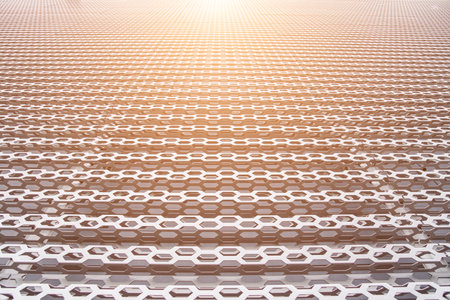 industrial background metallic wall construction of cells perspective foreshortening with light...
