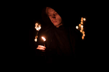 monk only one person hold candle with fire in warm darkness environment space faith concept soft focus photoの写真素材