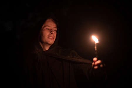 inspired male portrait with candle in hand night time story concept picture in darkness environment, soft focus on face and noise pollution themeの写真素材