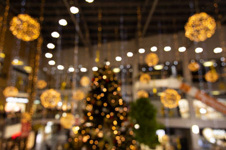 Shopping mall preparing for Christmas holidays indoor unfocused photography with yellow and golden garland and decoration illuminationの写真素材