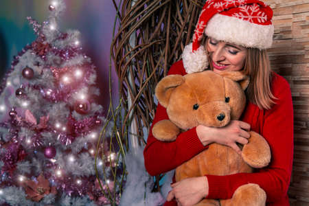 female portrait Christmas holidays season in decorated festive indoor studio room with garland lamps illumination backgroundの写真素材