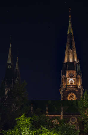 old urban cathedral tower architecture object vertical photography at night with lamp illuminations