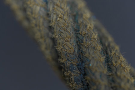 narrow focus macro view of thread wire elements isolated on dark meutral gray color background...