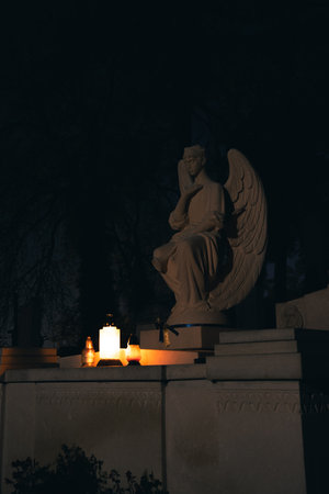 stone angel sculpture cemetery grave tomb stone architecture object at night with candle light vertical formatの写真素材