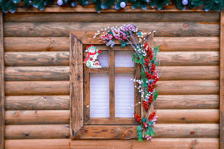 Christmas decoration wooden log cabin rural background window December winter holidays festive...