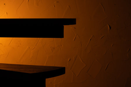 dark neon abstract interior silhouette construction design spiral shelf terraces on orange plaster textured wall surface background spaceの写真素材