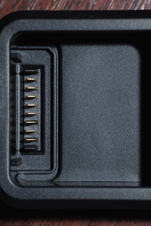 battery charger contacts black plastic device frame work vertical picture on table object