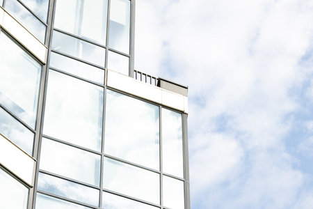 modern skyscraper office building external side of frame and glass windows frame work and neutral sky backgroundの写真素材